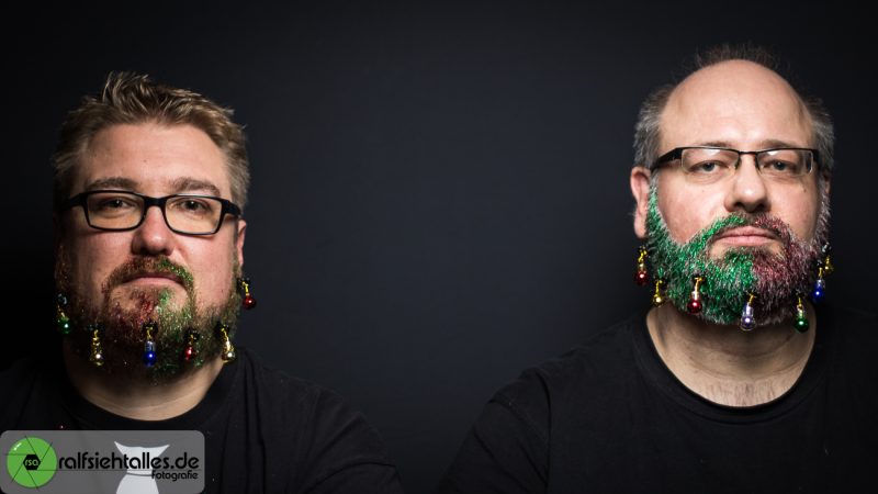 Tim und Ralf ernst beim Weihnachtsshooting mit Glitzerbärten und Weihnachtskugeln